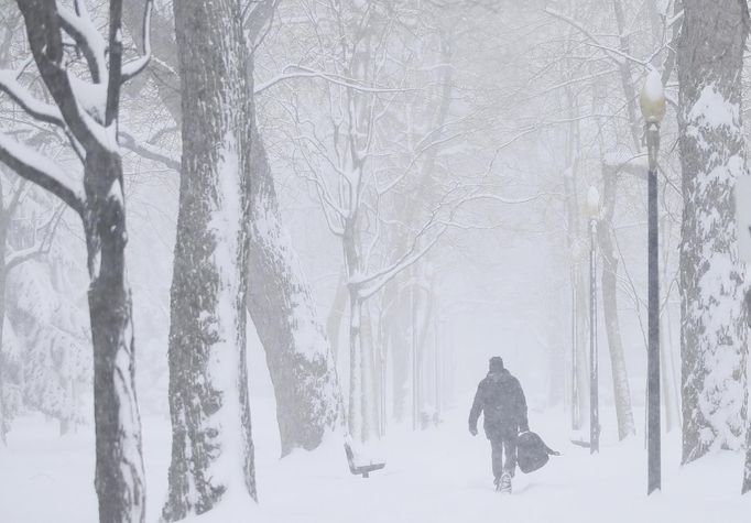 A man walks through a park as snow falls in Montreal, March 19, 2013. Quebec and the Maritimes were hit by a major snowstorm on the last official day of winter. REUTERS/Christinne Muschi (CANADA - Tags: SOCIETY ENVIRONMENT) Published: Bře. 19, 2013, 5:23 odp.