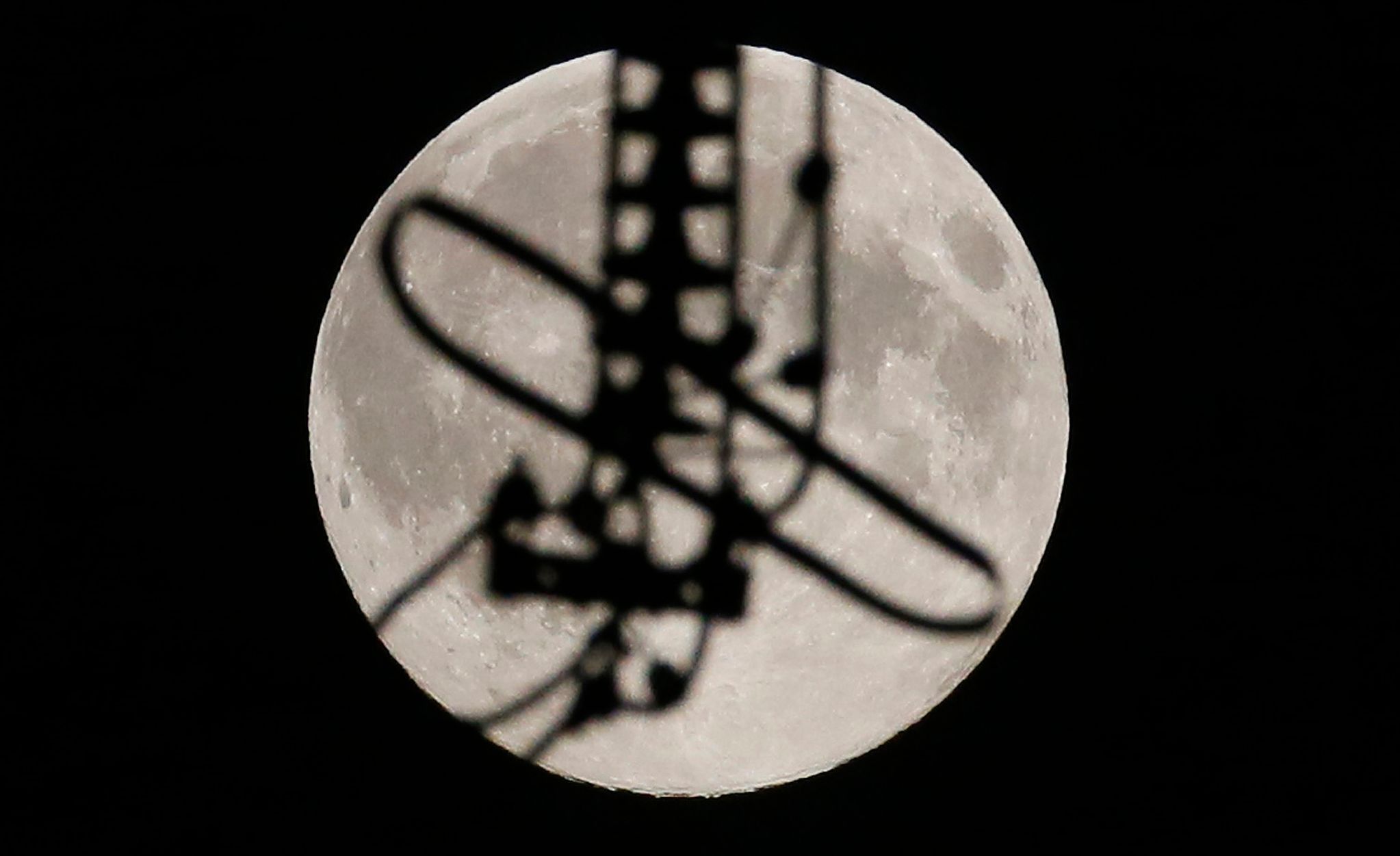 Supermoon is seen through parts of a high-voltage electric line at the Krasnoyarsk hydro electric power station in Russia's Siberian city of Krasnoyarsk