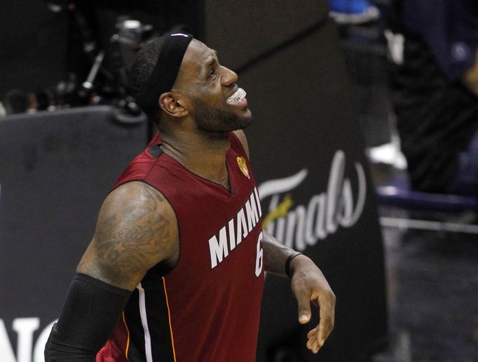 Miami Heat's LeBron James grimaces after hurting his leg during the fourth quarter against the San Antonio Spurs in Game 1 of their NBA Finals basketball series in San An