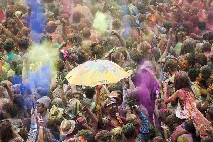 People throw coloured powder in the air during Holi festival celebrations in Berlin, July 29, 2012. Holi, also known as the festival of colours, is a festival celebrated in India and other Hindu countries that in its original form heralds the beginning of spring. The Berlin event brought Indian Djs, acrobatics and dance to the German capital. REUTERS/Thomas Peter (GERMANY - Tags: SOCIETY) Published: Čec. 29, 2012, 3:50 odp.