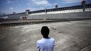 A man stands next to the Three Gorges dam in Yichang, Hubei province in this August 9, 2012 file photo. China relocated 1.3 million people during the 17 years it took to complete the Three Gorges dam. Even after finishing the $59 billion project last month, the threat of landslides along the dam's banks will force tens of thousands to move again. It's a reminder of the social and environmental challenges that have dogged the world's largest hydroelectric project. While there has been little protest among residents who will be relocated a second time, the environmental fallout over other big investments in China has become a hot-button issue ahead of a leadership transition this year. Picture taken on August 9, 2012. To match story CHINA-THREEGORGES/ REUTERS/Carlos Barria/Files(CHINA - Tags: POLITICS ENVIRONMENT BUSINESS ENERGY) Published: Srp. 22, 2012, 8:38 odp.