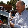 Chairman and CEO of McLaren Formula One team Dennis signs autographs at the first practice session of the Australian F1 Grand Prix in Melbourne