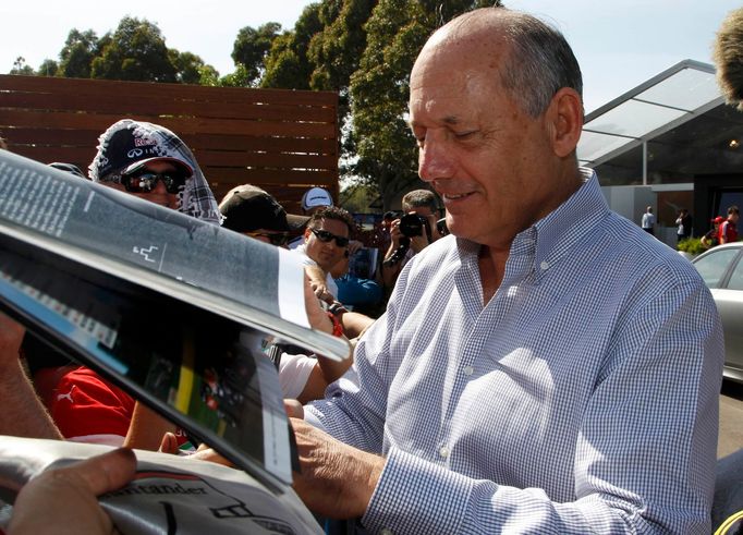 Chairman and CEO of McLaren Formula One team Ron Dennis signs autographs at the first practice session of the Australian F1 Grand Prix at the Albert Park circuit in Melbo