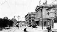 Průhled Wilsonovou ulicí s budovou Nového německého divadla (Státní opera), dnešní Wilsonovo nádraží v pozadí. Snímek pořízen mezi lety 1910 a 1915.