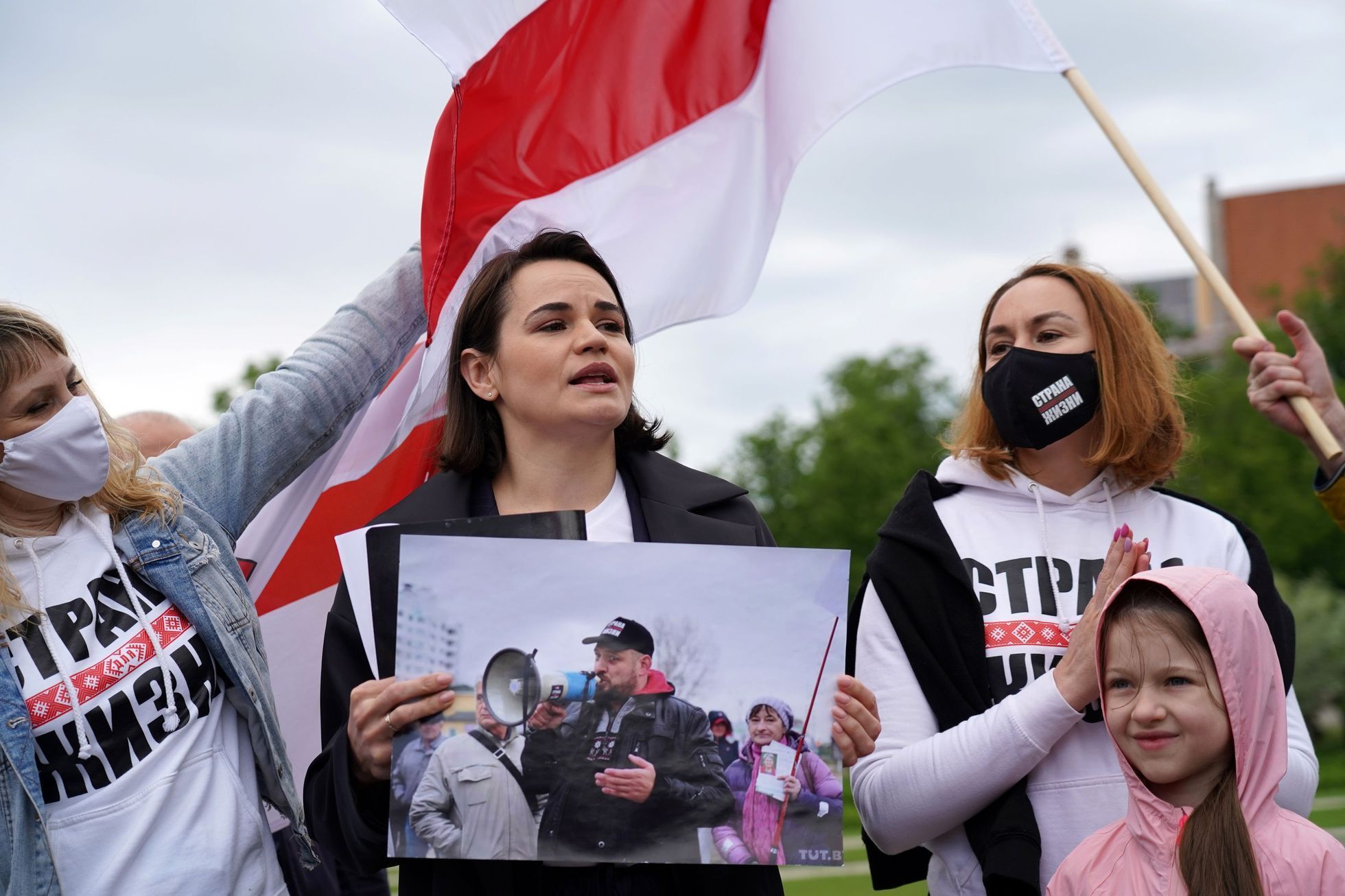 Svjatlana Cichanouská drží na mítinku ve Vilniusu fotografii svého manžela.