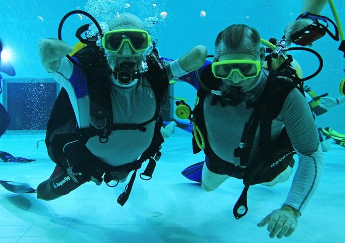 French athlete Philippe Croizon (L), whose arms and legs were amputated after an electric shock accident in March 1994, swims next to an unidentified diver in a 33 metre (36 yard) deep pool, the world's deepest pool built to train professional divers, at Nemo33 diving centre in Brussels January 10, 2013. Croizon, who swam with adapted prostheses that had flippers attached, broke a world record and became the first disabled person to dive to 33 metres, according to the organisers. REUTERS/Yves Herman (BELGIUM - Tags: SOCIETY SPORT DIVING TPX IMAGES OF THE DAY) Published: Led. 10, 2013, 4:40 odp.