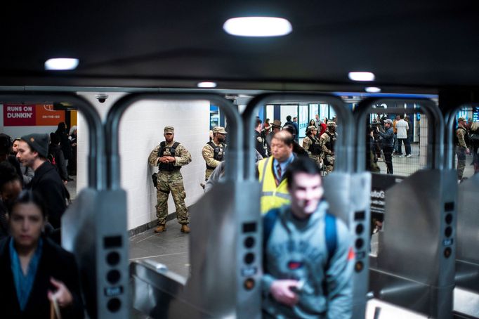 Policista a příslušníci Národní gardy státu New York hlídají kontrolní stanoviště pro kontrolu zavazadel u vchodu do stanice metra v New Yorku.