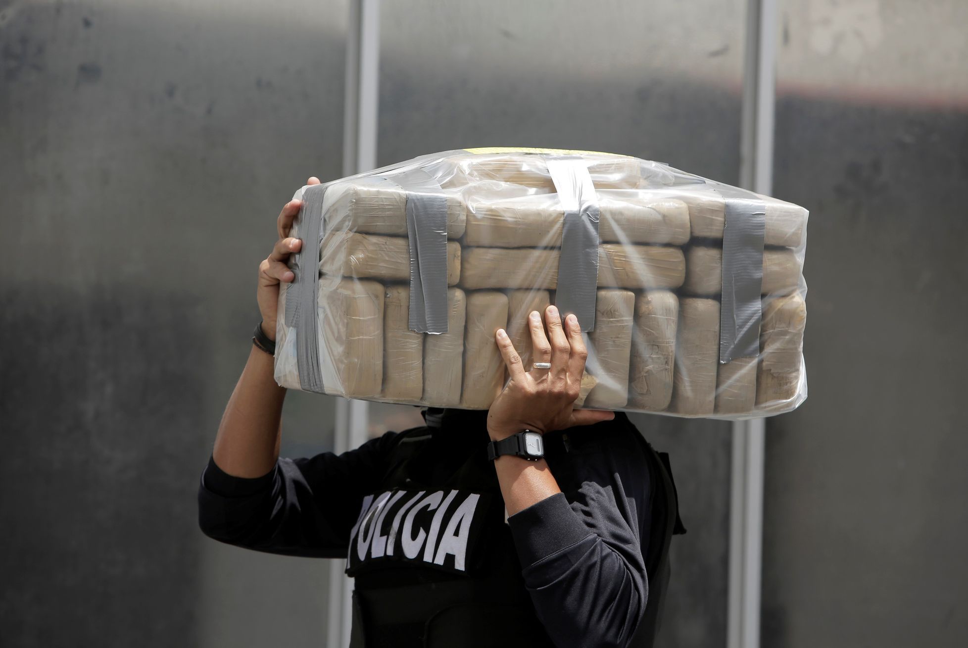 A police officer carries packages containing cocaine seized during operations over the last weekend, at the air base of the Ministry of Security in Alajuela