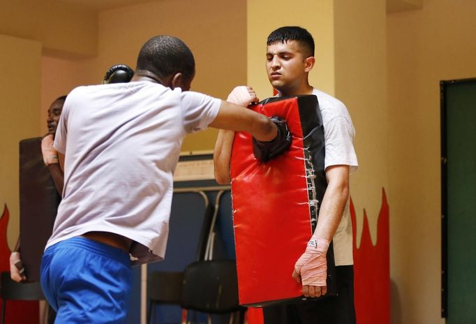 Unemployed Belgian Mohamed Sammar (C) takes part in a "Fit for a job" boxing class in Brussels July 1, 2013. Sammar, 27, has been looking for a job in the construction sector for 2 years. "Fit for a job" is the initiative of former Belgian boxing champion Bea Diallo, whose goal was to restore the confidence of unemployed people and help them find a job through their participation in sports. Picture taken July 1, 2013. REUTERS/Francois Lenoir (BELGIUM - Tags: SPORT BOXING SOCIETY BUSINESS EMPLOYMENT) Published: Čec. 5, 2013, 4:33 odp.