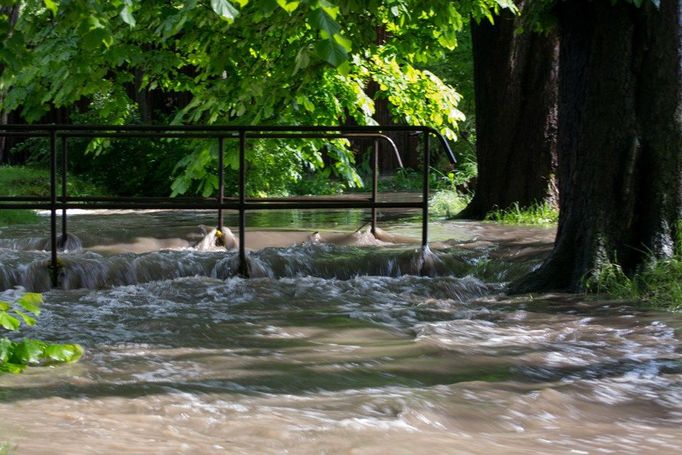 Fotografie z Podbořan na Lounsku, kde se jinak mírný potůček rozlil do okolních domů, sklepů a zahrádek.