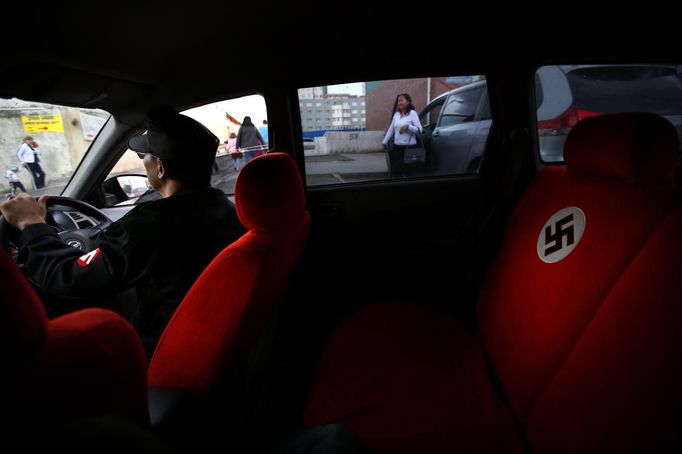 A swastika is seen on the seat of a car belonging to Ariunbold, leader of the Mongolian neo-Nazi group Tsagaan Khass, as he drives along a busy street in Ulan Bator June 22, 2013. The group has rebranded itself as an environmentalist organisation fighting pollution by foreign-owned mines, seeking legitimacy as it sends Swastika-wearing members to check mining permits. Over the past years, ultra-nationalist groups have expanded in the country and among those garnering attention is Tsagaan Khass, which has recently shifted its focus from activities such as attacks on women it accuses of consorting with foreign men to environmental issues, with the stated goal of protecting Mongolia from foreign mining interests. This ultra-nationalist group was founded in the 1990s and currently has 100-plus members. Picture taken June 22, 2013. REUTERS/Carlos Barria (MONGOLIA - Tags: POLITICS ENVIRONMENT BUSINESS SOCIETY EMPLOYMENT) ATTENTION EDITORS: PICTURE 12 OF 25 FOR PACKAGE 'MONGOLIA'S ENVIRONMENTAL NEO-NAZIS'. TO FIND ALL IMAGES SEARCH 'TSAGAAN KHASS' Published: Čec. 2, 2013, 9:58 dop.