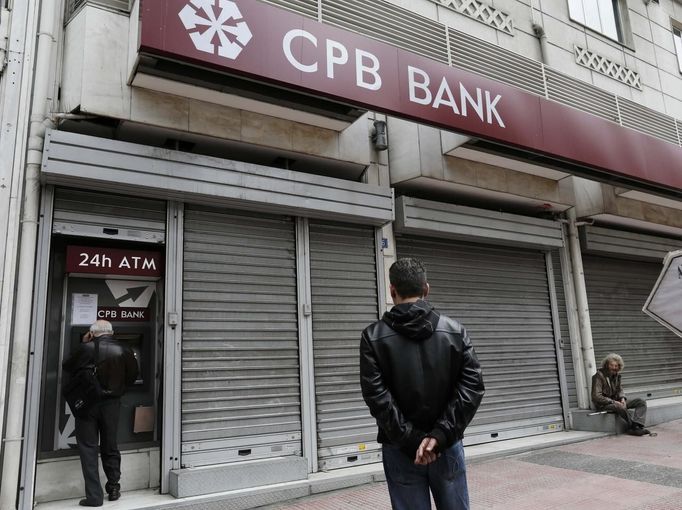 Lidé vybírají peníze z bankomatu zavřené pobočky kyperské banky Cyprus Popular Bank (CPB) v Athénách v Řecku.