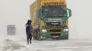 A man walks under heavy snow falls on the road between Cambra and Arras, northern France, March 12, 2013 as winter weather with snow and freezing temperatures returns to France. REUTERS/Pascal Rossignol (FRANCE - Tags: TRANSPORT ENVIRONMENT) Published: Bře. 12, 2013, 4:32 odp.