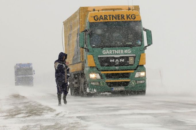 A man walks under heavy snow falls on the road between Cambra and Arras, northern France, March 12, 2013 as winter weather with snow and freezing temperatures returns to France. REUTERS/Pascal Rossignol (FRANCE - Tags: TRANSPORT ENVIRONMENT) Published: Bře. 12, 2013, 4:32 odp.