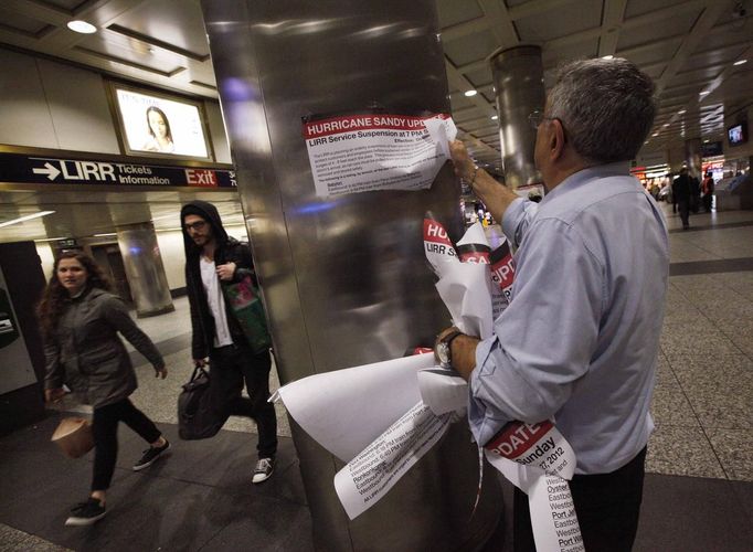 A Station agent takes down signage announcing suspension of train service after the departure of the last train Long Island railroad train at Penn Station in New York, October 28, 2012. Authorities shut transit systems and ordered some evacuations as tens of millions of people on the East Coast braced for Hurricane Sandy, a gigantic storm forecast to deliver battering winds, dangerous flooding and even heavy snowfall. REUTERS/Brendan McDermid (UNITED STATES - Tags: DISASTER ENVIRONMENT)