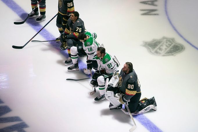 Jason Dickinson (18) s Tylerem Seguinem (91) z Dallasu a Ryan Reaves (75) s brankářem Robinem Lehnerem (90) z Vegas protestovali při hymně pokleknutím.