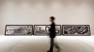 A visitor walks past pictures representing the "uncreation" theme, by famed Czech photographer Josef Koudelka, at the Holy See pavilion