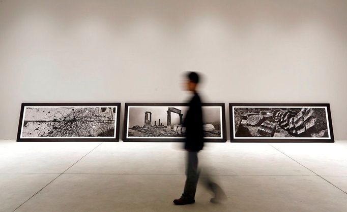 A visitor walks past pictures representing the "uncreation" theme, by famed Czech photographer Josef Koudelka, at the Holy See pavilion