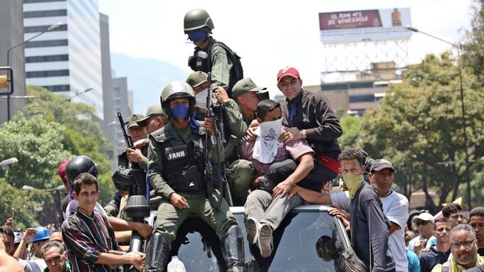 Vojáci, kteří podporují vůdce opozice Juana Guaidóa, projíždějí ulicemi Caracasu s dalšími příznivci samozvaného prezidenta Venezuely.