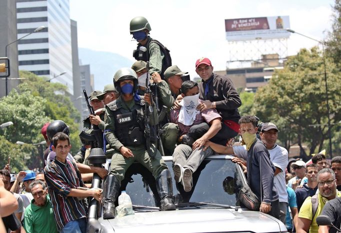 Vojáci, kteří podporují vůdce opozice Juana Guaidóa, projíždějí ulicemi Caracasu s dalšími příznivci samozvaného prezidenta Venezuely.