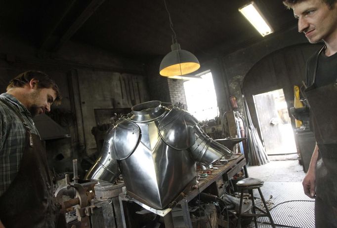 Blacksmith brothers Johann (R) and Georg Schmidberger work on a harness for the Vatican Swiss Guard at their workshop in Molln, Upper Austria June 12, 2012. Johann, 29, and Georg, 28, produce made-to-order handmade harnesses for the Vatican, which take 120 hours of handiwork per piece and hardly differs from the 500-year-old originals. The brothers carry on the tradition of the blacksmith trade in the fifth generation of their family. REUTERS/Lisi Niesner (AUSTRIA - Tags: SOCIETY MILITARY) Published: Čer. 12, 2012, 10:16 odp.