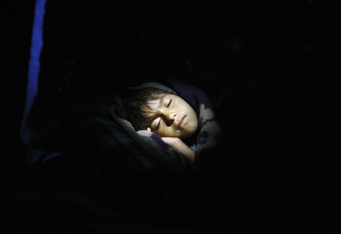 Shivani Choudhary, 7, a street performer sleeps on her hut at the slum on the bank of Manahara River after a whole day of street performance in Kathmandu August 15, 2012. Shivani and her brothers Drumpal and Gchan, who came to Kathmandu from India 5 years ago, earn their living by performing tricks on the streets of Kathmandu. According to Drumpal, Shivani's older brother, they earn around $10 a day by performing tricks, which is not enough to feed their 10-member family living together in a small hut without a proper toilet or any basic needs. REUTERS/Navesh Chitrakar (NEPAL - Tags: SOCIETY POVERTY IMMIGRATION) Published: Srp. 15, 2012, 4:35 odp.