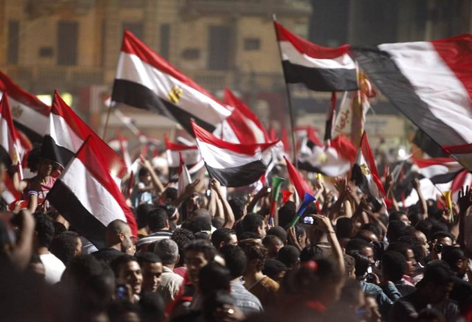 Anti-Mursi protesters walk with their flags as they celebrate in Tahrir square after the announcement of the removal from office of Egypt's deposed President Mohamed Mursi in Cairo, July 3, 2013. Mursi, toppled by the military on Wednesday, is being held by the authorities, a Muslim Brotherhood spokesman and a security official said on Thursday. REUTERS/Asmaa Waguih (EGYPT - Tags: POLITICS CIVIL UNREST) Published: Čec. 4, 2013, 1:26 dop.