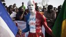 REFILE - CORRECTING IPTC CREDIT A Malian man painted in the colours of the French flag and with the words reading: "Welcome the savior Francois Hollande" poses for a picture before the arrival of France's President Francois Hollande at the Independence Plaza in Bamako, Mali February 2, 2013. France will withdraw its troops from Mali once the Sahel state has restored sovereignty over its national territory and a U.N.-backed African military force can take over from the French soldiers, Hollande said on Saturday. REUTERS/Joe Penney (MALI - Tags: POLITICS CONFLICT) Published: Úno. 2, 2013, 8:23 odp.