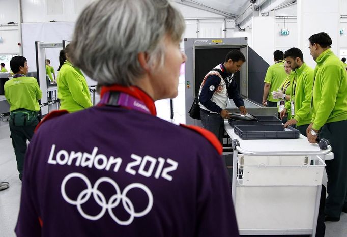 Indian shooting team member Sanjeev Rajput holds his laptop as he goes through a security check at the Welcome Center near the Athletes' Village at the Olympic Park in London July 18, 2012. REUTERS/Jae C. Hong/Pool (BRITAIN - Tags: SPORT OLYMPICS SHOOTING) Published: Čec. 18, 2012, 6:47 odp.