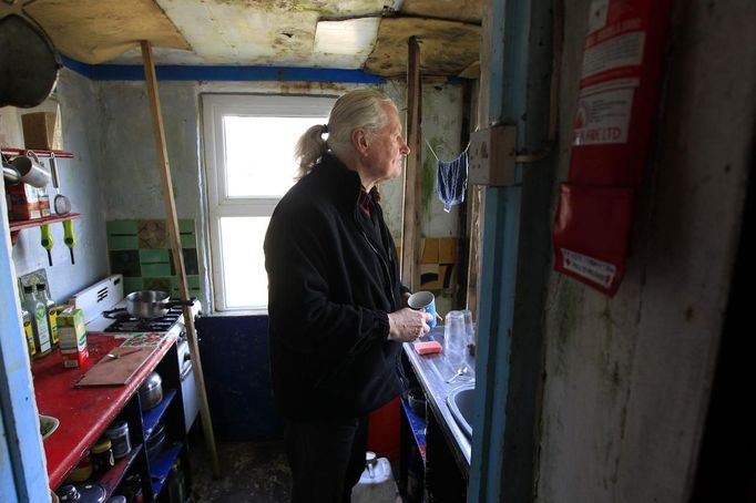 Artist and poet Barry Edgar Pilcher, age 69, poses for a photograph as he makes a cup of coffee in his cottage on the Island of Inishfree in County Donegal May 1, 2012. Pilcher is the only inhabitant of the island on which he has lived for the past 20 years. He only leaves the island once a week to collect his pension and buy groceries on the mainland. . REUTERS/Cathal McNaughton (IRELAND - Tags: ENTERTAINMENT SOCIETY) Published: Kvě. 2, 2012, 1:41 odp.