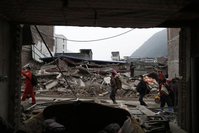 People walk past a damaged building after Saturday's earthquake in Lingguan town of Baoxing county, Sichuan province April 22, 2013. The 6.6 magnitude quake struck in Lushan county, near the city of Ya'an in the southwestern province of Sichuan, close to where a devastating 7.9 quake hit in May 2008, killing 70,000. The earthquake killed at least 186 people and injured more than 11,000, state media said. REUTERS/Aly Song (CHINA - Tags: DISASTER ENVIRONMENT) Published: Dub. 22, 2013, 1:38 odp.