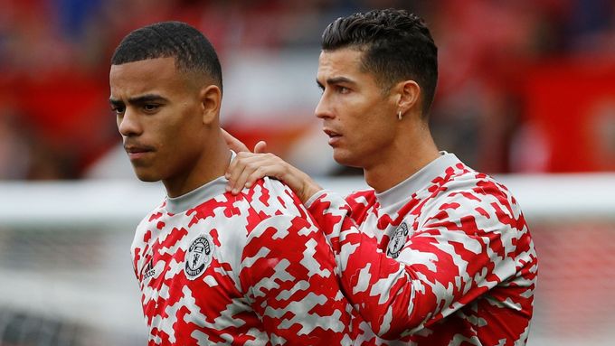 Cristiano Ronaldo (vpravo) se s Masonem Greenwoodem v kabině Manchesteru United ani na sociálních sítích minimálně nějakou dobu potkávat...