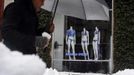 A pedestrian walks past mannequins wearing swim suits in a window on Newbury Street during a late winter snow storm in Boston, Massachusetts March 19, 2013. REUTERS/Brian Snyder (UNITED STATES - Tags: ENVIRONMENT) Published: Bře. 19, 2013, 3:48 odp.