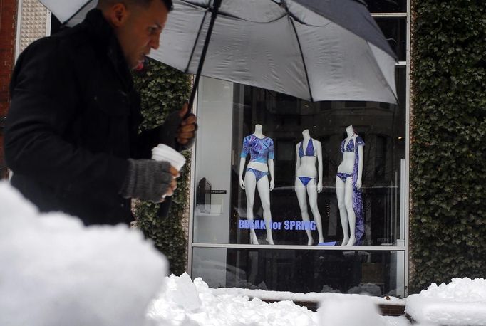 A pedestrian walks past mannequins wearing swim suits in a window on Newbury Street during a late winter snow storm in Boston, Massachusetts March 19, 2013. REUTERS/Brian Snyder (UNITED STATES - Tags: ENVIRONMENT) Published: Bře. 19, 2013, 3:48 odp.