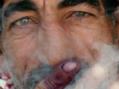 Iráčan si dává cigaretu, protože úspěšně odvolil.