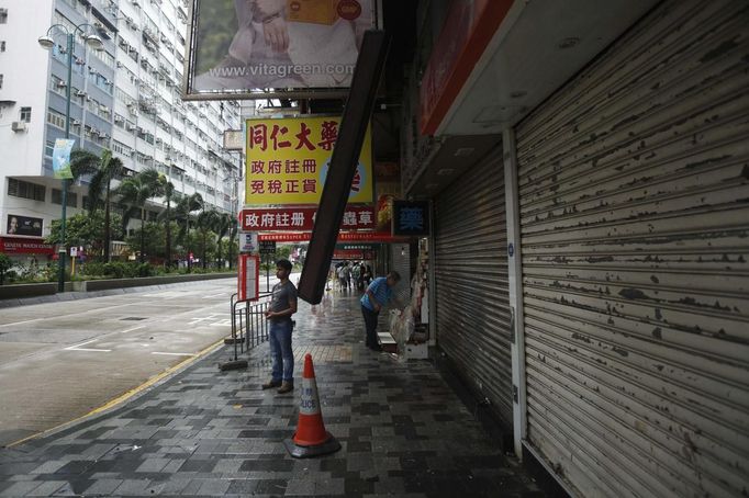 A man stands near a damaged electronic advertisement board after Typhoon Vicente hit Hong Kong July 24, 2012. A severe typhoon hit Hong Kong on Tuesday, disrupting business across the financial hub, with offices and the stock market to remain closed for at least part of the morning after the city raised its highest typhoon warning overnight. REUTERS/Tyrone Siu (CHINA - Tags: ENVIRONMENT DISASTER BUSINESS) Published: Čec. 24, 2012, 3:08 dop.