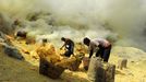 This photo taken on December 25, 2010 shows Indonesian miners filling baskets with sulphur before carrying them from the bottom of the crater of Indonesia's active Kajah