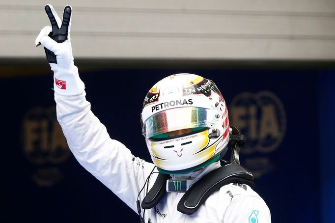 Mercedes Formula One driver Lewis Hamilton of Britain gestures as he celebrates taking pole position after the qualifying session for the Chinese F1 Grand Prix at the Sha