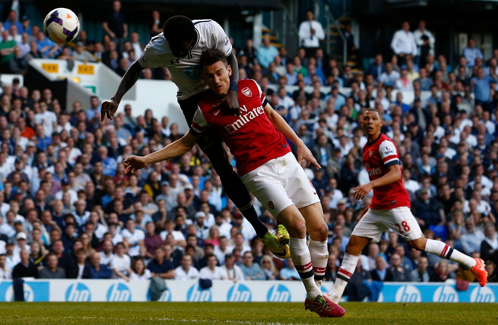 Tottenham Hotspur's Adebayor gets above Arsenal's Koscielny to head at goal during their English Premier League soccer match in London