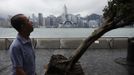 A man reacts while walking past an uprooted tree after Typhoon Vicente hit Hong Kong July 24, 2012. A severe typhoon hit Hong Kong on Tuesday, disrupting business across the financial hub, with offices and the stock market to remain closed for at least part of the morning after the city raised its highest typhoon warning overnight. REUTERS/Tyrone Siu (CHINA - Tags: ENVIRONMENT DISASTER BUSINESS CITYSPACE TPX IMAGES OF THE DAY) Published: Čec. 24, 2012, 3:12 dop.