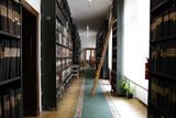 Vstupní chodba archivu Knihovny Národního muzea lemovaná vysokými regály plnými svázaných novin a časopisů ze všech období naší země.