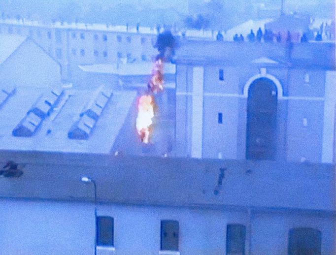 Fotoreprodukce z dobového VHS videozáznamu policejních složek ČSSR, který zachytil potlačení vzpoury vězňů ve věznici Leopoldov v březnu roku 1990.