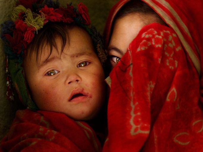 Hazarská dívka (Hazarové jsou národnost ve středním Afghánistánu, pozn. red.) skrývá svou tvář před fotografem v provincii Bamiyan, 15. prosinec 2001.