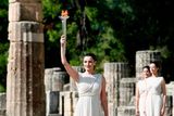 Představitelka hlavní kněžky Naflpitou s planoucím olympijským ohněm.