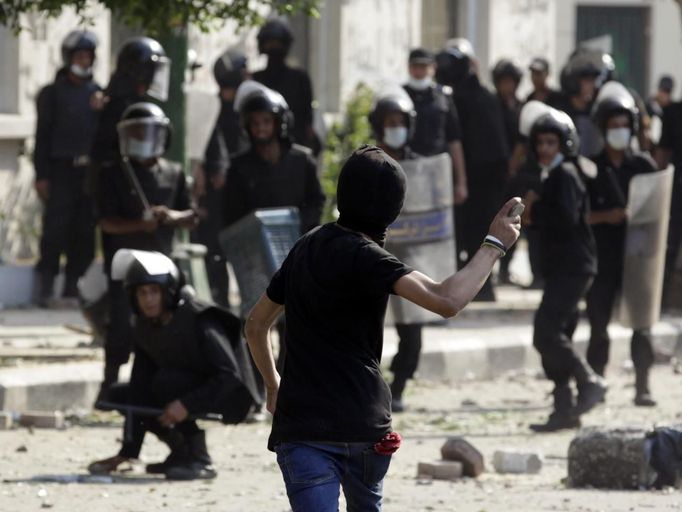 A protester throws a stone towards riot police, during clashes along a road which leads to the U.S. embassy, near Tahrir Square in Cairo September 13, 2012.