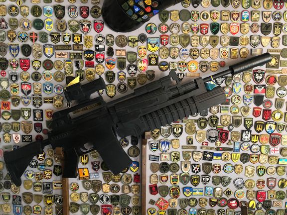 Maketa zbraně na stěně kyjevské Pizzerie Veterano.