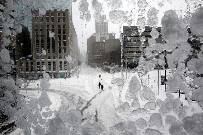 People walk through snow covered streets in Copley Square during a blizzard in Boston, Massachusetts February 9, 2013. REUTERS/Jessica Rinaldi (UNITED STATES - Tags: ENVIRONMENT TPX IMAGES OF THE DAY) Published: Úno. 9, 2013, 5:43 odp.