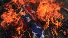 A burning U.S. flag is seen on the ground after it was set on fire by Bangladeshi Muslims during a protest in front of the National Press Club in Dhaka September 21, 2012. About 10,000 Bangladeshi Muslims participated in demonstrations after Friday prayers in Bangladesh's capital against an anti-Islam film made in the U.S. and also against cartoons mocking the Prophet Mohammad published on Wednesday in a French magazine. REUTERS/Andrew Biraj (BANGLADESH - Tags: RELIGION POLITICS CIVIL UNREST) Published: Zář. 21, 2012, 11:09 dop.