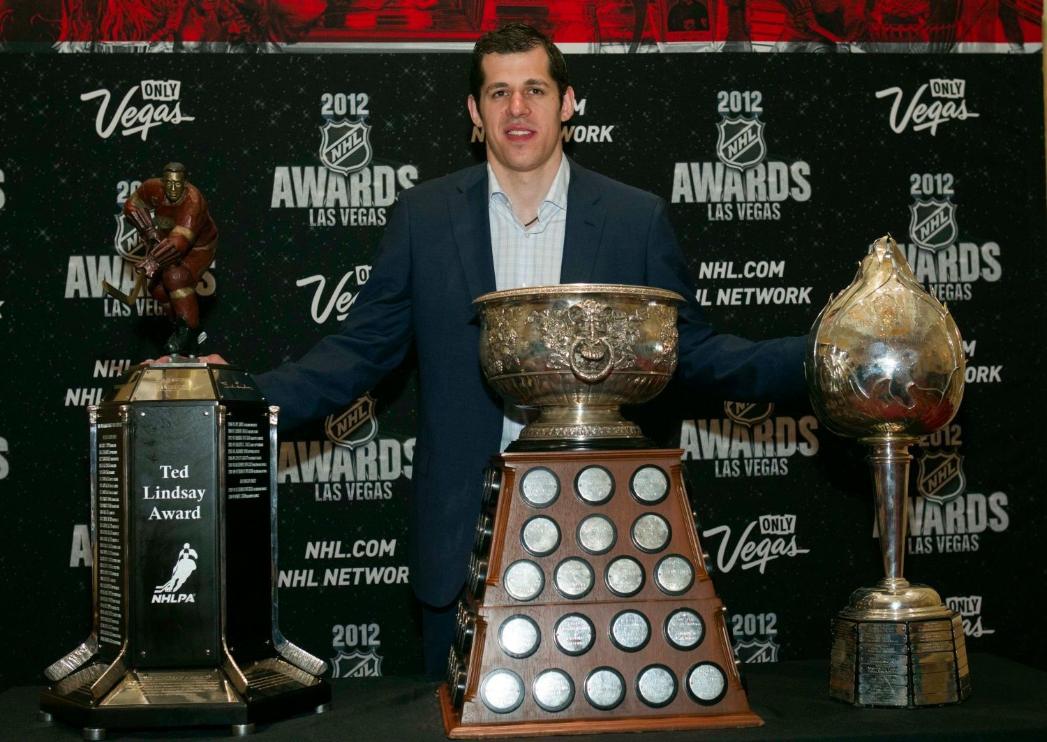 Útočník Pittsburghu Penguins Jevgenij Malkin pózuje s Ted Lindsay Award, Art Ross Trophy a Hart Trophy během předávání trofejí NHL v Las Vegas za sezónu 2011/12