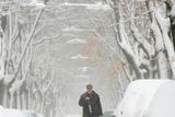 Muž odhrabuje sníh z vídeňské ulice